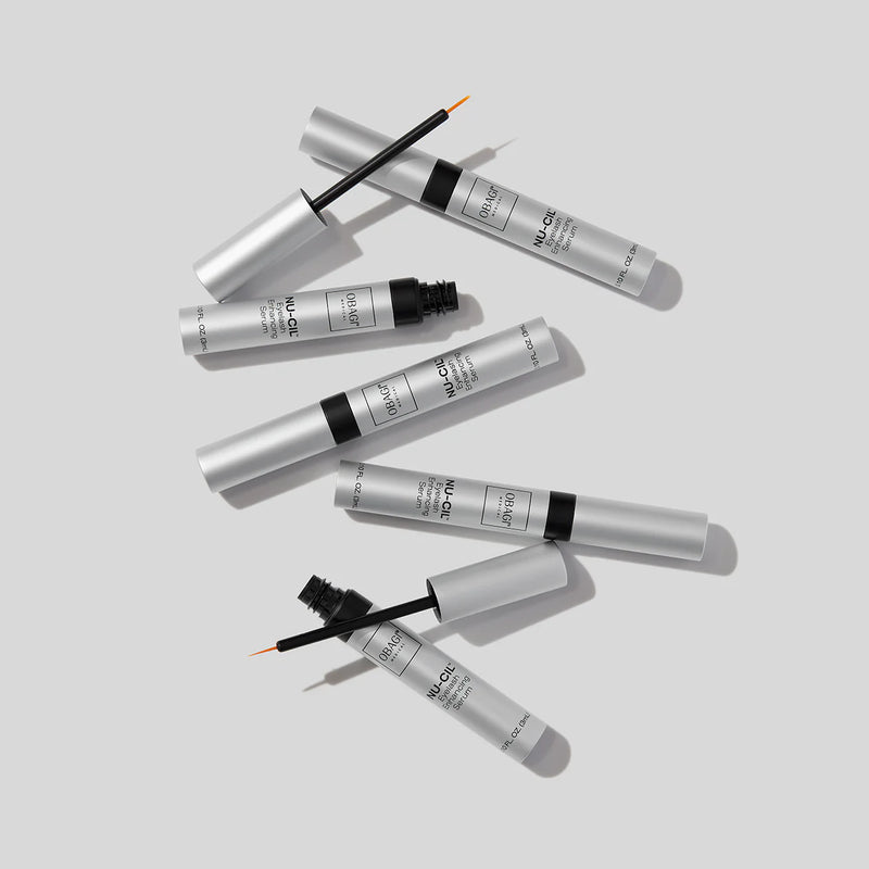 An image of five bottles of Nu-Cil™ Eyelash Enhancing Serum, two of which had their cap opened.